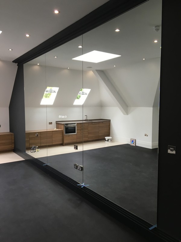 Frameless glass partition in loft conversion by Walworth glaziers